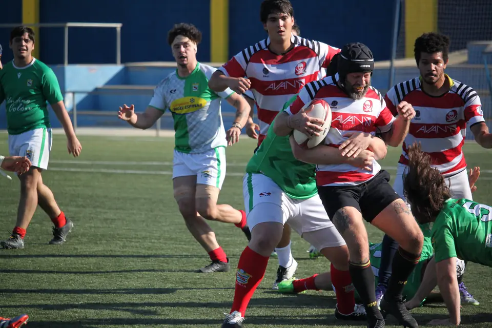 Un jugador del senior de Bucaneros carga con el balón entre placadores en el IV Trofeo García de la Rosa